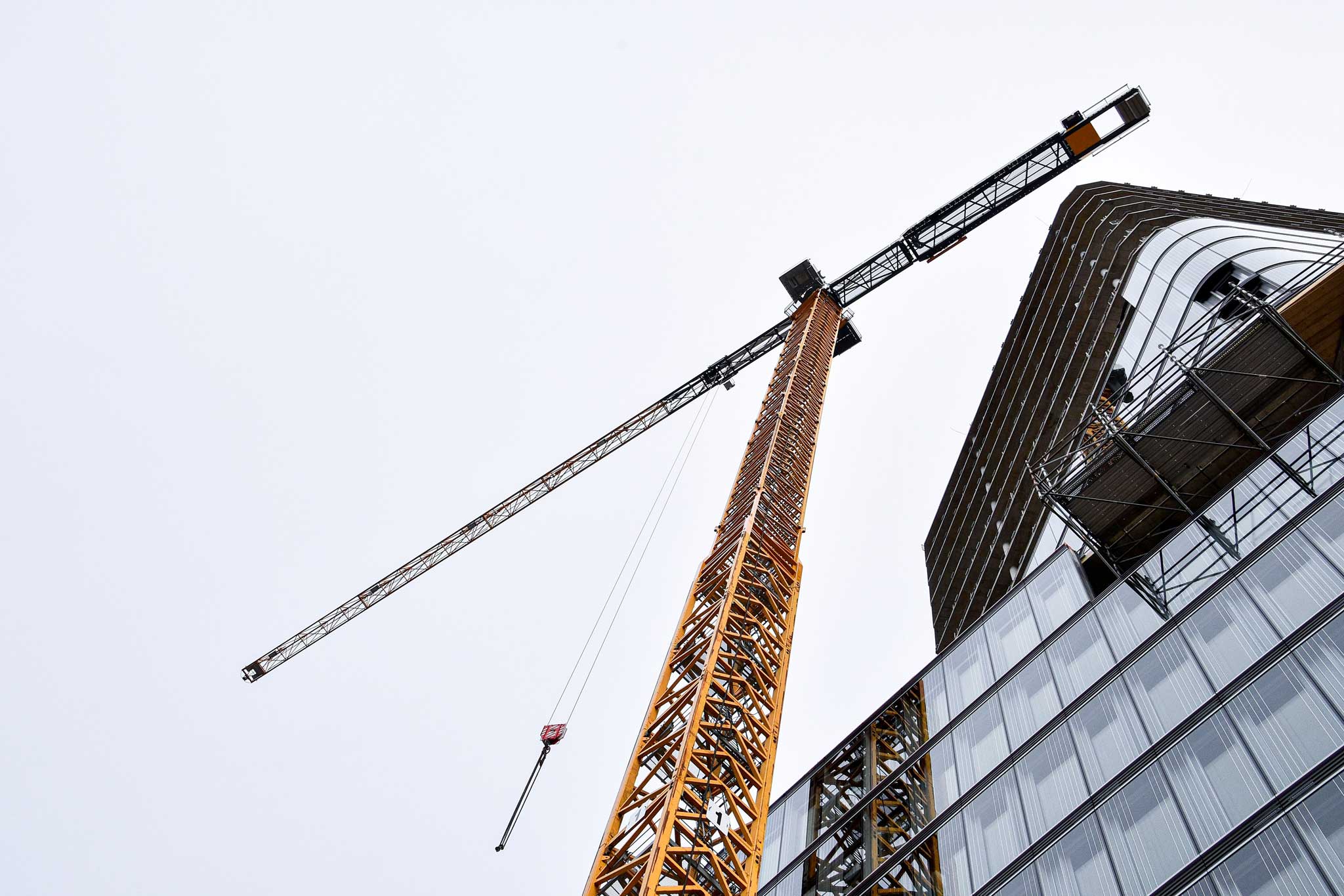 Crane constructing steel frame for building.